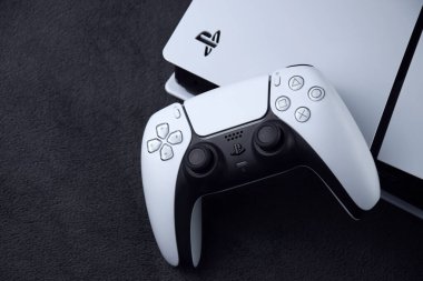 Kharkiv, Ukrayna - 10 Temmuz 2025: Beyaz Sony PlayStation 5 ve karanlık masa üzerindeki denetleyici.