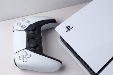 Kharkiv, Ukrayna - 10 Temmuz 2025: Beyaz Sony PlayStation 5 ve beyaz masadaki denetleyici.