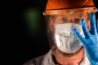 Avustralya 'da laboratuvar önlüğü ve eldiven giyerken maske ve yüz maskesi takan Covid doktor ve sağlık görevlisi..