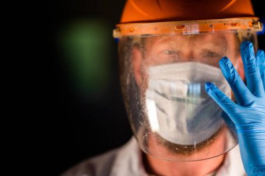 Avustralya 'da laboratuvar önlüğü ve eldiven giyerken maske ve yüz maskesi takan Covid doktor ve sağlık görevlisi..