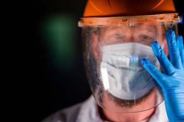 Avustralya 'da laboratuvar önlüğü ve eldiven giyerken maske ve yüz maskesi takan Covid doktor ve sağlık görevlisi..