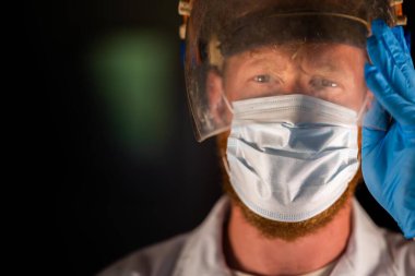 Avustralya 'da laboratuvar önlüğü ve eldiven giyerken maske ve yüz maskesi takan Covid doktor, hemşire ve sağlık görevlisi. Salgın sırasında hastaneye kaldırıldı..