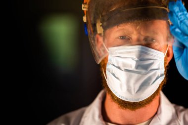 Avustralya 'da laboratuvar önlüğü ve eldiven giyerken maske ve yüz maskesi takan Covid doktor, hemşire ve sağlık görevlisi. Salgın sırasında hastaneye kaldırıldı..