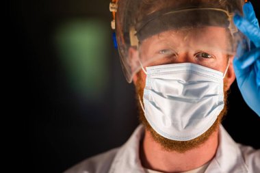 Avustralya 'da laboratuvar önlüğü ve eldiven giyerken maske ve yüz maskesi takan Covid doktor, hemşire ve sağlık görevlisi. Salgın sırasında hastaneye kaldırıldı..