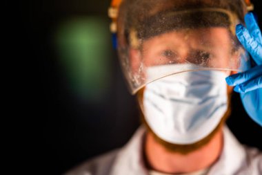 Avustralya 'da laboratuvar önlüğü ve eldiven giyerken maske ve yüz maskesi takan Covid doktor, hemşire ve sağlık görevlisi. Salgın sırasında hastaneye kaldırıldı..