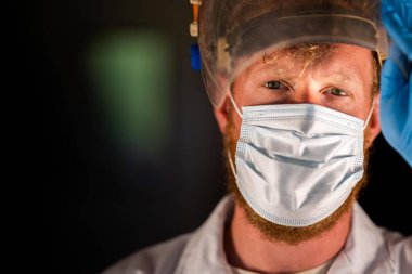 Avustralya 'da laboratuvar önlüğü ve eldiven giyerken maske ve yüz maskesi takan Covid doktor, hemşire ve sağlık görevlisi. Salgın sırasında hastaneye kaldırıldı..