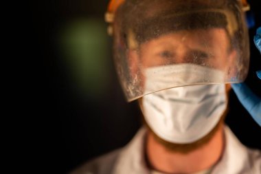 Avustralya 'da laboratuvar önlüğü ve eldiven giyerken maske ve yüz maskesi takan Covid doktor, hemşire ve sağlık görevlisi. Salgın sırasında hastaneye kaldırıldı..