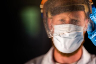 Avustralya 'da laboratuvar önlüğü ve eldiven giyerken maske ve yüz maskesi takan Covid doktor, hemşire ve sağlık görevlisi. Salgın sırasında hastaneye kaldırıldı..