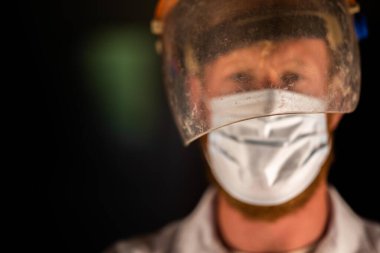 Avustralya 'da laboratuvar önlüğü ve eldiven giyerken maske ve yüz maskesi takan Covid doktor, hemşire ve sağlık görevlisi. Salgın sırasında hastaneye kaldırıldı..