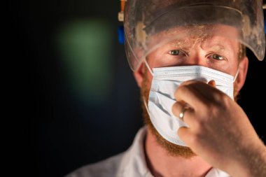 Avustralya 'da laboratuvar önlüğü ve eldiven giyerken maske ve yüz maskesi takan Covid doktor, hemşire ve sağlık görevlisi. Salgın sırasında hastaneye kaldırıldı..