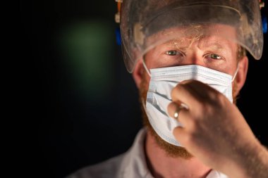 Avustralya 'da laboratuvar önlüğü ve eldiven giyerken maske ve yüz maskesi takan Covid doktor, hemşire ve sağlık görevlisi. Salgın sırasında hastaneye kaldırıldı..