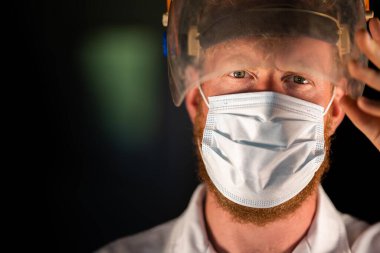 Avustralya 'da laboratuvar önlüğü ve eldiven giyerken maske ve yüz maskesi takan Covid doktor, hemşire ve sağlık görevlisi. Salgın sırasında hastaneye kaldırıldı..