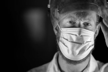 Avustralya 'da laboratuvar önlüğü ve eldiven giyerken maske ve yüz maskesi takan Covid doktor, hemşire ve sağlık görevlisi. Salgın sırasında hastaneye kaldırıldı..