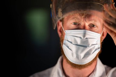 Avustralya 'da laboratuvar önlüğü ve eldiven giyerken maske ve yüz maskesi takan Covid doktor, hemşire ve sağlık görevlisi. Salgın sırasında hastaneye kaldırıldı..