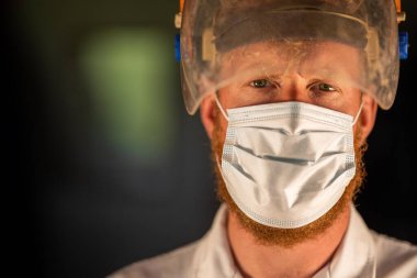 Avustralya 'da laboratuvar önlüğü ve eldiven giyerken maske ve yüz maskesi takan Covid doktor, hemşire ve sağlık görevlisi. Salgın sırasında hastaneye kaldırıldı..