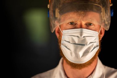 Avustralya 'da laboratuvar önlüğü ve eldiven giyerken maske ve yüz maskesi takan Covid doktor, hemşire ve sağlık görevlisi. Salgın sırasında hastaneye kaldırıldı..