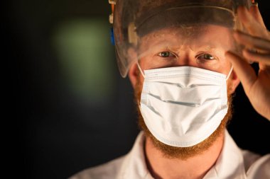 Avustralya 'da laboratuvar önlüğü ve eldiven giyerken maske ve yüz maskesi takan Covid doktor, hemşire ve sağlık görevlisi. Salgın sırasında hastaneye kaldırıldı..