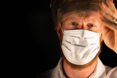 Avustralya 'da laboratuvar önlüğü ve eldiven giyerken maske ve yüz maskesi takan Covid doktor, hemşire ve sağlık görevlisi. Salgın sırasında hastaneye kaldırıldı..