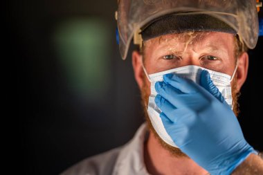 Avustralya 'da laboratuvar önlüğü ve eldiven giyerken maske ve yüz maskesi takan Covid doktor, hemşire ve sağlık görevlisi. Salgın sırasında hastaneye kaldırıldı..