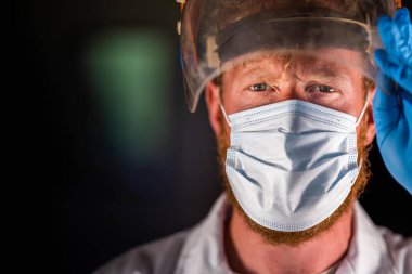 Avustralya 'da laboratuvar önlüğü ve eldiven giyerken maske ve yüz maskesi takan Covid doktor, hemşire ve sağlık görevlisi. Salgın sırasında hastaneye kaldırıldı..