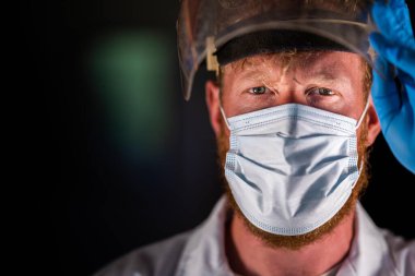 Avustralya 'da laboratuvar önlüğü ve eldiven giyerken maske ve yüz maskesi takan Covid doktor, hemşire ve sağlık görevlisi. Salgın sırasında hastaneye kaldırıldı..