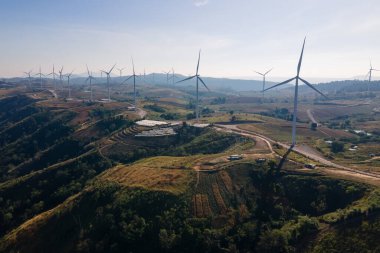 Rüzgar türbinleri tarlası ve gündoğumu. temiz enerji, çevre, elektrik ve sanayi kavramı