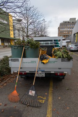 Dietikon, İsviçre - 24 Kasım 2020: Yeşilliğin yapraklarını sonbahar temizliği ve budaması yapan bir bahçe hizmetleri aracı