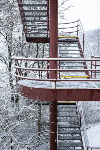 Exterior red metal stairs of an industrial building in Zurich in a snowy winter