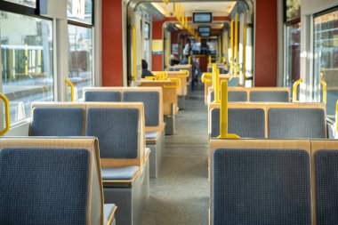 Zürih 'teki tramvay vagonunda boş tahta koltuklar.
