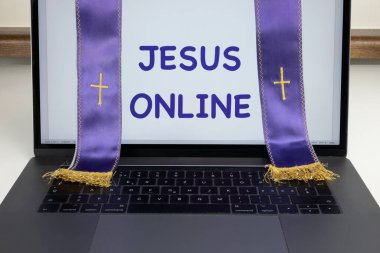 A purple priest stole across a laptop computer screen saying Jesus online clipart