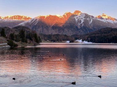 Sonbahar akşamları güneş İsviçre 'nin St. Moritz gölünün arkasında batar.