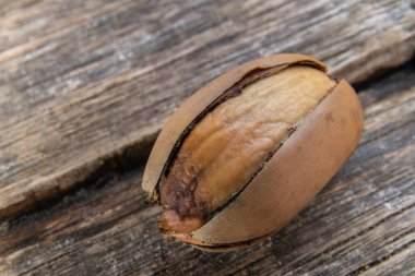 Ahşap bir arka planda kırık kabuklu bir meşe palamudunun makro fotoğrafı