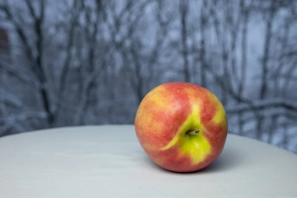 Een Appel Met Een Natuurlijke Winterachtergrond Van Besneeuwde Bomen — Stockfoto