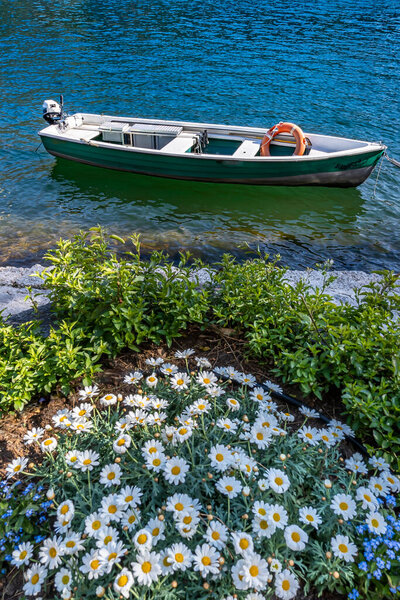 A green fishing boat on the shores of Swiss Lake Lugano in Morcote in Ticino