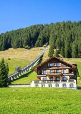 Murren, İsviçre - 2 Ekim 2025: Murren 'de Allmendhubel funicular demiryolu ile geleneksel alp evi, güneşli bir günde güzel dağ doğası