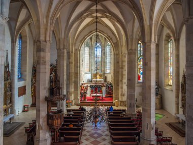 Bratislava, Slovakya - 19 Ekim 2025: Yüksek tavanlı, vitray pencereli ve ahşap sıralı St. Martin katedralinin içi.