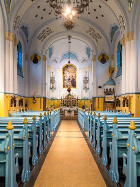 Bratislava, Slovakya - 19 Ekim 2025: Bratislava 'da mavi sıraları, sunakları ve dini eserleri olan renkli mavi bir kilisenin içi
