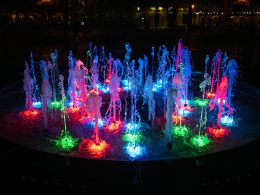 Bratislava şehrinin aydınlık binaları ve ışıkları yansıtan bir Tuna nehri manzarası..