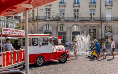 Nantes, Fransa - 5 Ağustos 2025: Place Graslin 'in tarihi mimarisi ve Nantes, Brittany' de bir şehir caddesinde kızıl turist treni.