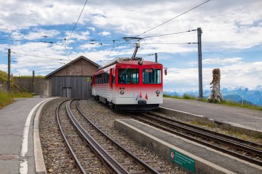 Rigi, İsviçre - 17 Temmuz 2025: Rigi Dağı demiryolu manzaralı kırmızı ve beyaz tren.