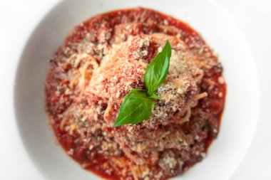 Üzerine fesleğen yaprağı konmuş İtalyan usulü makarna salamı. Geleneksel Et Yemeği Geçmişli Spagetti. Kırmızı domates soslu makarna ve peynir..