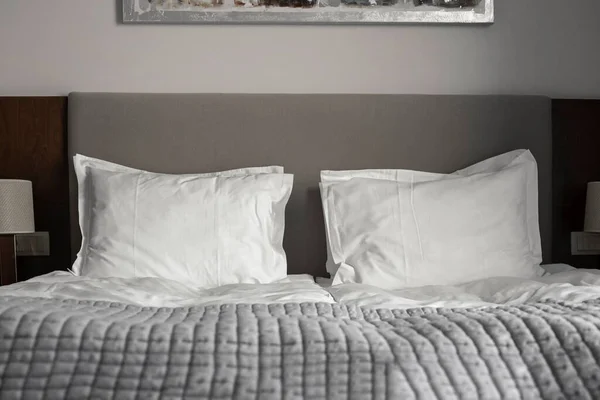 Yatakta iki beyaz pamuk yastık. Yorgan Battaniyesi ile rahat bir yatak odası. Seçici Odaklanma.