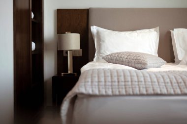 Yatak, yastık, lamba ve battaniyeli oda. Tatil ya da İş Gezisi İçin Konforlu Yatak Odası.