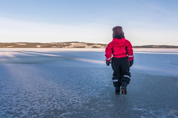 Child walking on frozen lake. — Stock Photo, Image