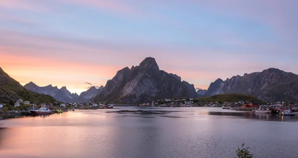 Reine, Lofoten, Norvège. Village de pêcheurs avec pic de montagne aigu Image En Vente