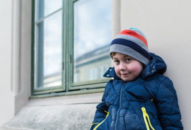 Duvara yaslanmış çocuk