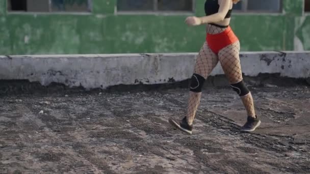 Due ragazze si incontrano sul tetto di un edificio abbandonato e iniziano a ballare twerk. Ragazze in pantaloncini rossi e collant a scacchi. — Video Stock