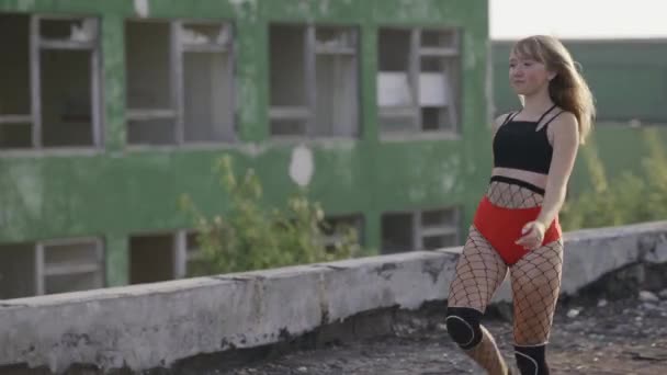 Två flickor möts på taket till en övergiven byggnad och börjar dansa twerk. Flickor i röda shorts och rutiga tights. — Stockvideo