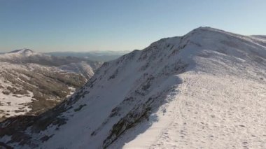 Karpatlar 'daki Brebeneskul Gölü. Kış dağlarının hava fotoğrafçılığı. Güneşli bir günde karla kaplı zirveler.