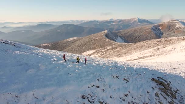 세 명의 여행자가 산에서 내려온다. 겨울 카르파티아인들의 눈덮인 봉우리. 공중에서 본 광경. — 비디오